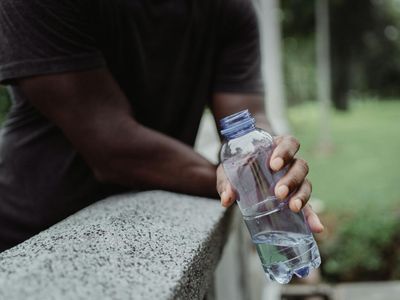 Person hands holding a water bottle after exercise